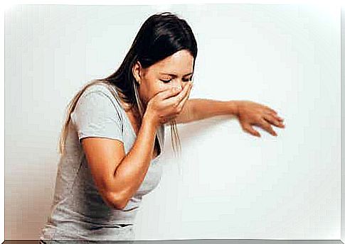 A woman who covers her mouth with her hand because she feels nauseous.